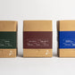 Three cardboard boxes with different colored labels on a white background